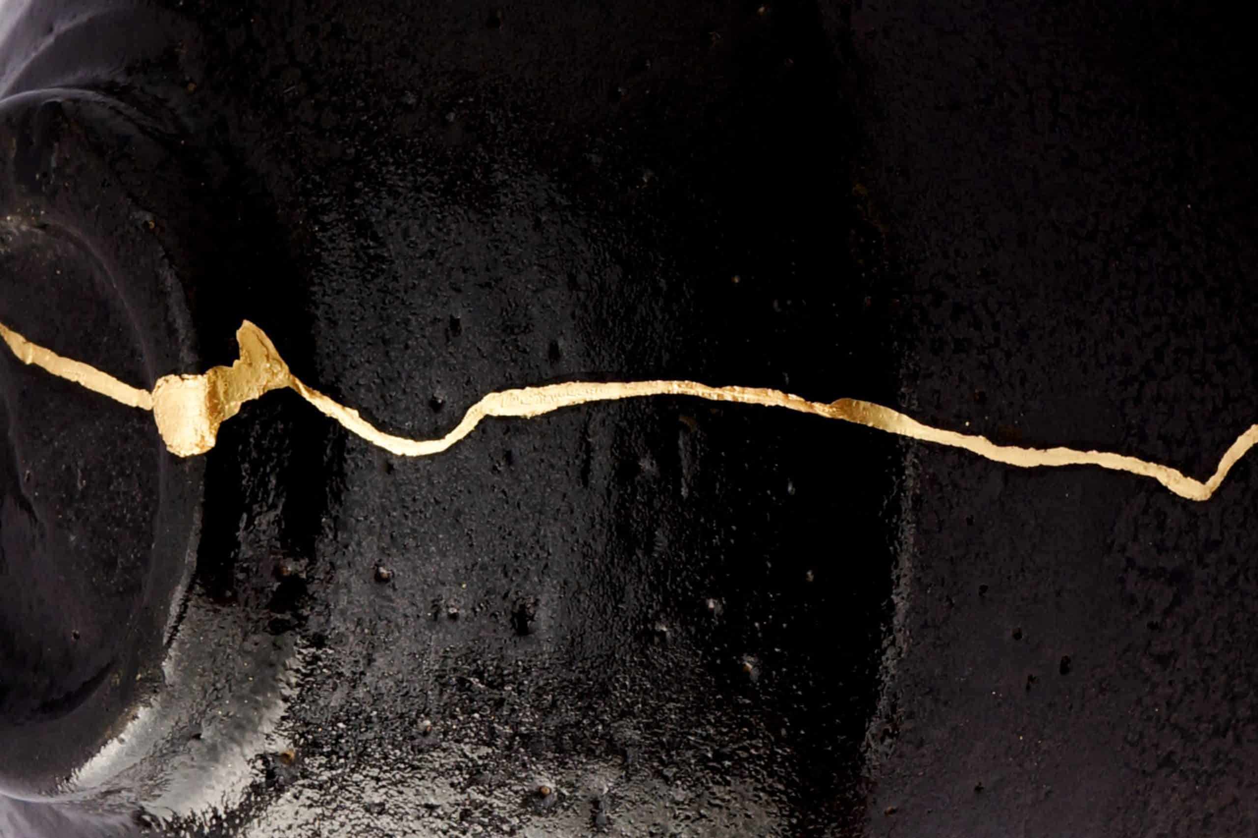Kintsugi trace doré sur céramique noir sublimant la cassure du vase