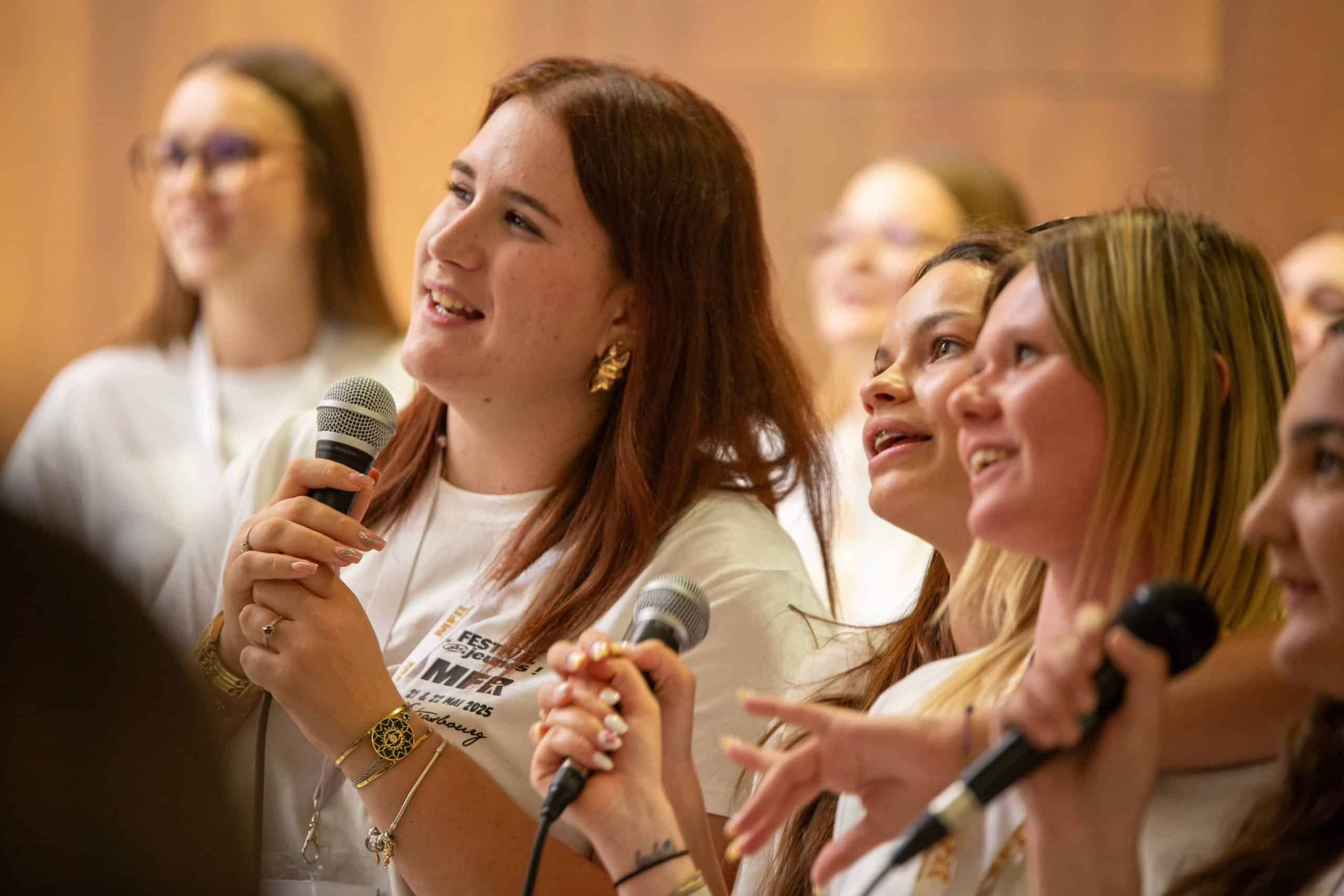 Groupe de jeunes femmes chantant joyeusement au micro lors d’un événement du festival MFR à Strasbourg en mai 2025