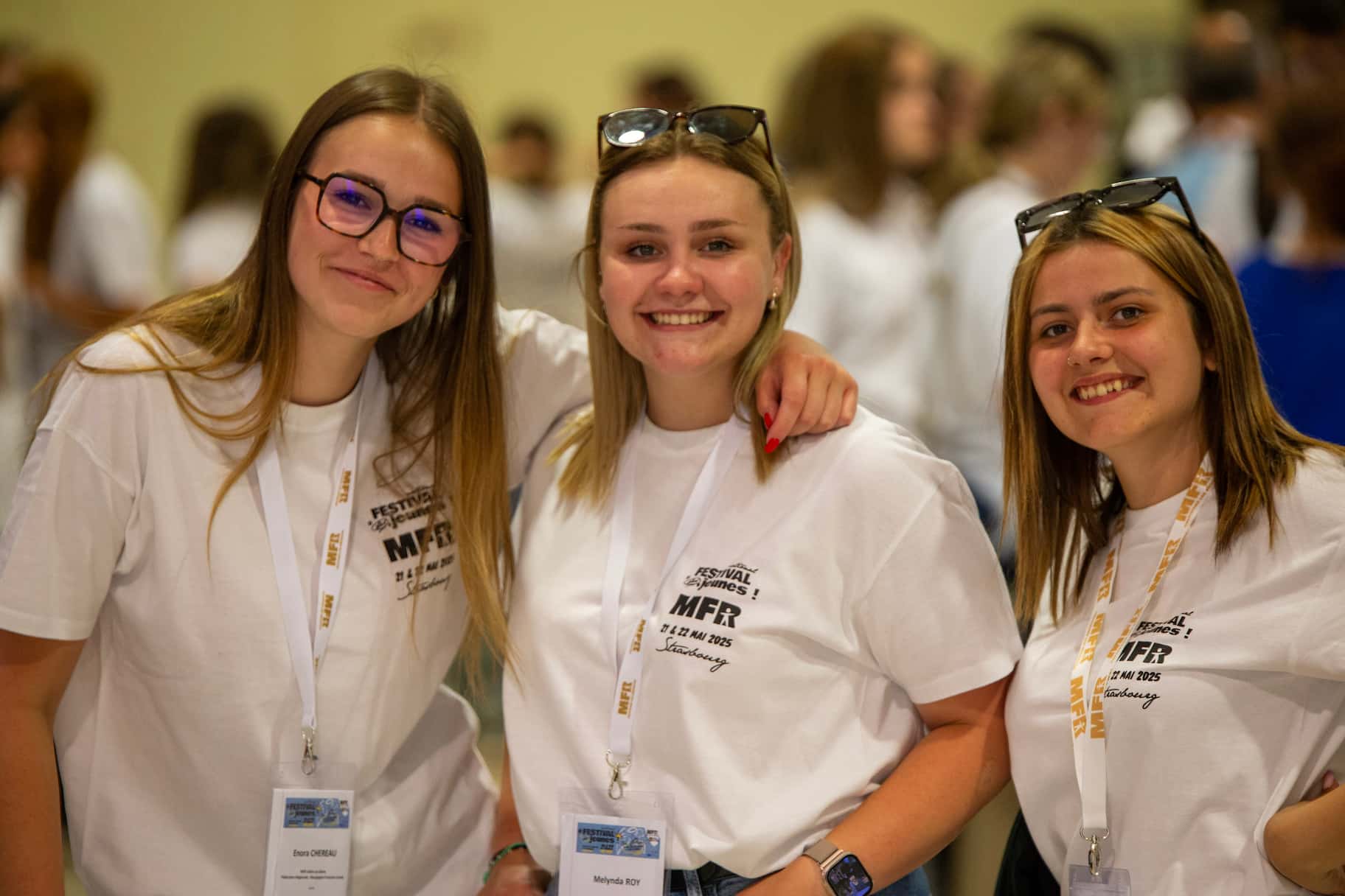 Trois participantes du Festival MFR 2025 souriantes et complices, posant pour une photo avec leur badge à Strasbourg